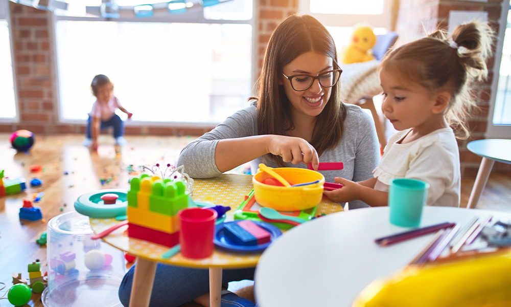 Tips to Finding the Right Childcare Putting Your Child First - Teacher and Toddlers Playing on the Table With Lots of Toys